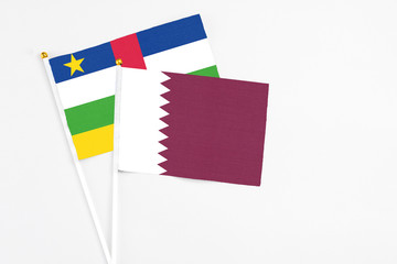 Qatar and Central African Republic stick flags on white background. High quality fabric, miniature national flag. Peaceful global concept.White floor for copy space.