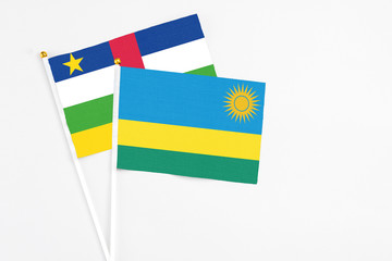 Rwanda and Central African Republic stick flags on white background. High quality fabric, miniature national flag. Peaceful global concept.White floor for copy space.
