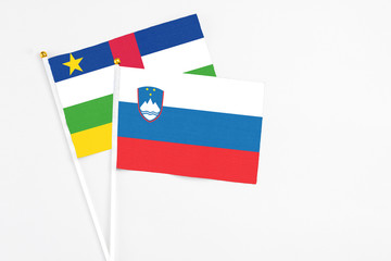 Slovenia and Central African Republic stick flags on white background. High quality fabric, miniature national flag. Peaceful global concept.White floor for copy space.