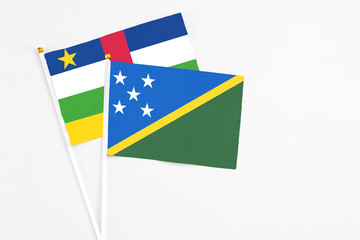 Solomon Islands and Central African Republic stick flags on white background. High quality fabric, miniature national flag. Peaceful global concept.White floor for copy space.