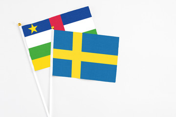 Sweden and Central African Republic stick flags on white background. High quality fabric, miniature national flag. Peaceful global concept.White floor for copy space.