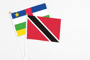 Trinidad And Tobago and Central African Republic stick flags on white background. High quality fabric, miniature national flag. Peaceful global concept.White floor for copy space.