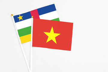 Vietnam and Central African Republic stick flags on white background. High quality fabric, miniature national flag. Peaceful global concept.White floor for copy space.