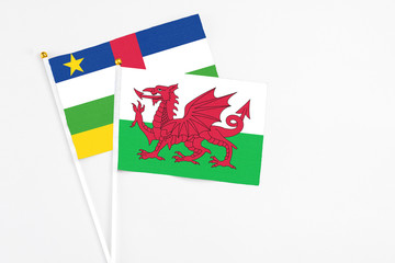 Wales and Central African Republic stick flags on white background. High quality fabric, miniature national flag. Peaceful global concept.White floor for copy space.
