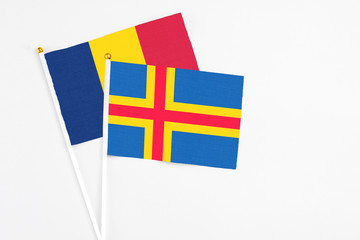 Aland Islands and Chad stick flags on white background. High quality fabric, miniature national flag. Peaceful global concept.White floor for copy space.