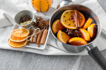 christmas and seasonal drinks concept - pot with hot mulled wine, orange slices, aromatic spices...
