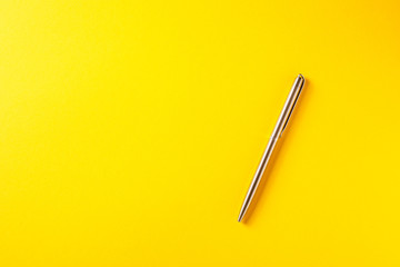 metal pen isolated on yellow background