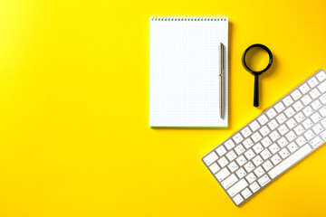 the white open notepad and computer keypad isolated on the yellow