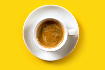 Black coffee in a cup on a yellow background