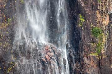 Zoomed in shot of Wallaman falls spray and cliff in Queensland, Australia.