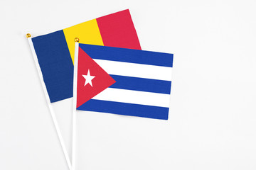 Cuba and Chad stick flags on white background. High quality fabric, miniature national flag. Peaceful global concept.White floor for copy space.