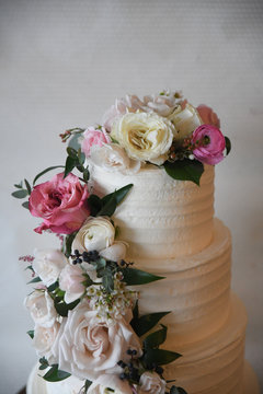 White cake with tiers and a floral vine decoration