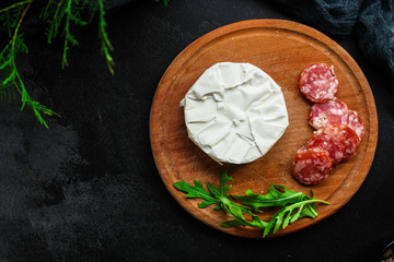 camembert or brie, cheese plate appetizer, snack (cheese with mold and sausage) menu concept. food background. top view. copy space
