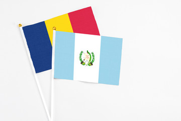 Guatemala and Chad stick flags on white background. High quality fabric, miniature national flag. Peaceful global concept.White floor for copy space.