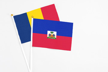 Haiti and Chad stick flags on white background. High quality fabric, miniature national flag. Peaceful global concept.White floor for copy space.