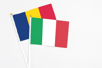 Fototapeta premium Italy and Chad stick flags on white background. High quality fabric, miniature national flag. Peaceful global concept.White floor for copy space.