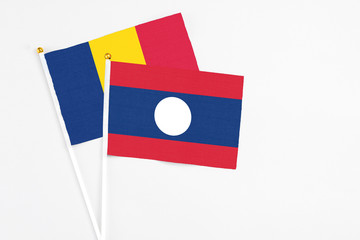 Laos and Chad stick flags on white background. High quality fabric, miniature national flag. Peaceful global concept.White floor for copy space.