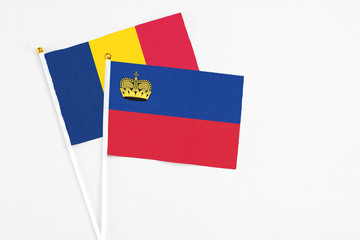 Liechtenstein and Chad stick flags on white background. High quality fabric, miniature national flag. Peaceful global concept.White floor for copy space.