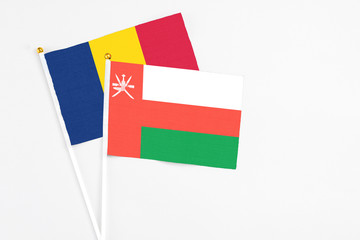 Oman and Chad stick flags on white background. High quality fabric, miniature national flag. Peaceful global concept.White floor for copy space.
