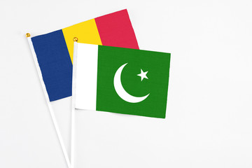 Pakistan and Chad stick flags on white background. High quality fabric, miniature national flag. Peaceful global concept.White floor for copy space.