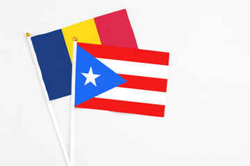 Puerto Rico and Chad stick flags on white background. High quality fabric, miniature national flag. Peaceful global concept.White floor for copy space.