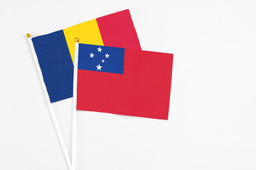 Samoa and Chad stick flags on white background. High quality fabric, miniature national flag. Peaceful global concept.White floor for copy space.