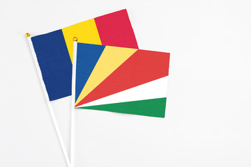 Seychelles and Chad stick flags on white background. High quality fabric, miniature national flag. Peaceful global concept.White floor for copy space.