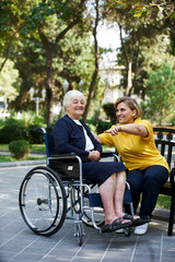 Obraz na płótnie Canvas Professional helpful caregiver and handicapped senior woman.