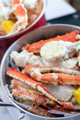 Close up on garlic and crab legs in stock pot for a seafood boil