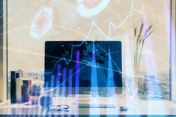 Stock market graph on background with desk and personal computer. Multi exposure. Concept of financial analysis.