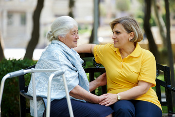 Daughter cares for mother. Health visitor and a senior woman
