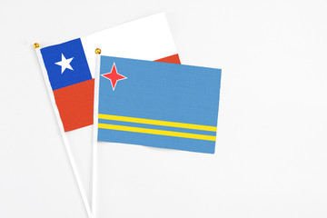 Aruba and Chile stick flags on white background. High quality fabric, miniature national flag. Peaceful global concept.White floor for copy space.