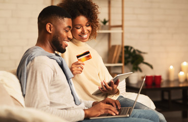 E-Commerce concept. African-american couple using laptop at home