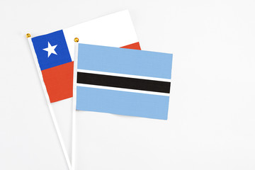 Botswana and Chile stick flags on white background. High quality fabric, miniature national flag. Peaceful global concept.White floor for copy space.