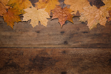 Naklejka na ściany i meble Autumn leaves on rustic wooden table. Thanksgiving background. Top view with copy space.