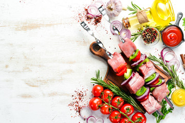 Raw veal kebab with rosemary and vegetables. Top view. Free space for your text.