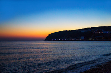 Orange sunset over the sea, the sun went downhill. The village of Novomikhailovsky.