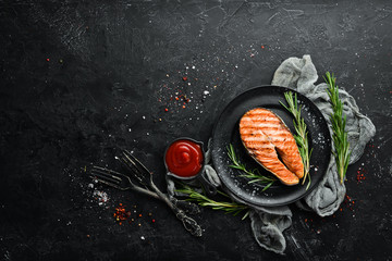 Grilled salmon steak with rosemary and spices. Top view. Free space for your text.