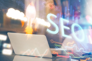 Multi exposure of table with computer and seo drawing hologram. Search optimization concept.
