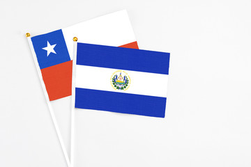 El Salvador and Chile stick flags on white background. High quality fabric, miniature national flag. Peaceful global concept.White floor for copy space.