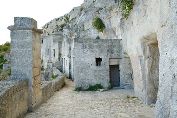 Road and facades of the Sassi of Matera. Doors and windows of ancient underground houses carved...