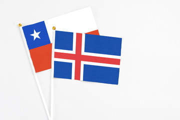 Iceland and Chile stick flags on white background. High quality fabric, miniature national flag. Peaceful global concept.White floor for copy space.