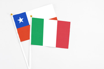 Italy and Chile stick flags on white background. High quality fabric, miniature national flag. Peaceful global concept.White floor for copy space.