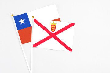 Jersey and Chile stick flags on white background. High quality fabric, miniature national flag. Peaceful global concept.White floor for copy space.