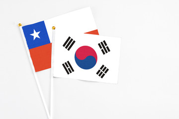 South Korea and Chile stick flags on white background. High quality fabric, miniature national flag. Peaceful global concept.White floor for copy space.