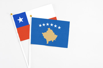 Kosovo and Chile stick flags on white background. High quality fabric, miniature national flag. Peaceful global concept.White floor for copy space.