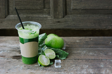 Green apple smoothie in glass and kale leaves on wooden table - 302508798