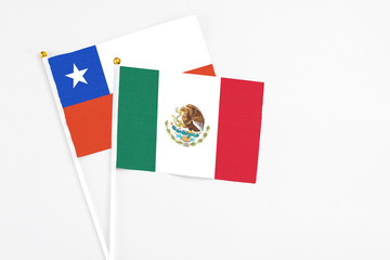 Mexico and Chile stick flags on white background. High quality fabric, miniature national flag. Peaceful global concept.White floor for copy space.