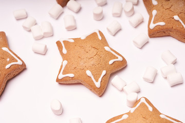 White marshmallows and Christmas ginger cookies on a white background, top view. Winter Christmas sweet food