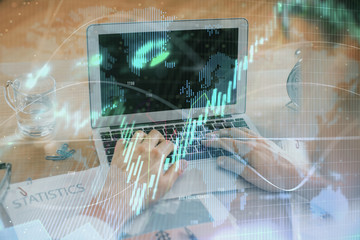 Multi exposure of market chart with man working on computer on background. Concept of financial analysis.